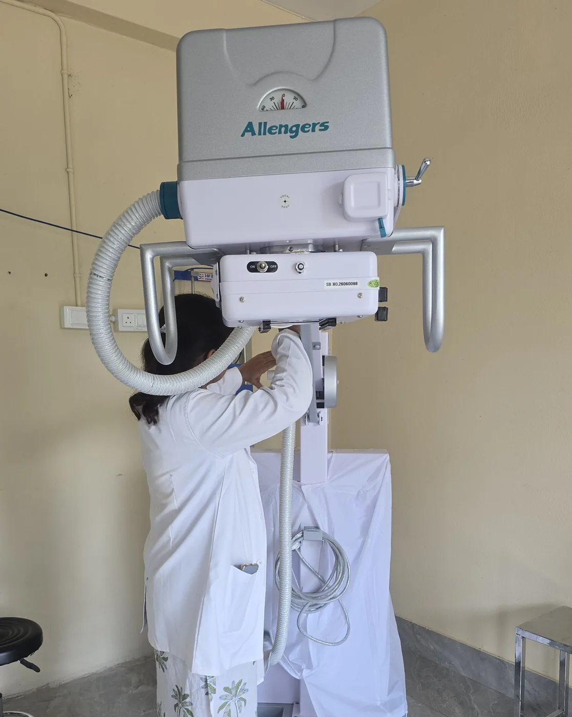 A technician positioning the Allengers X-ray unit in the radiography room